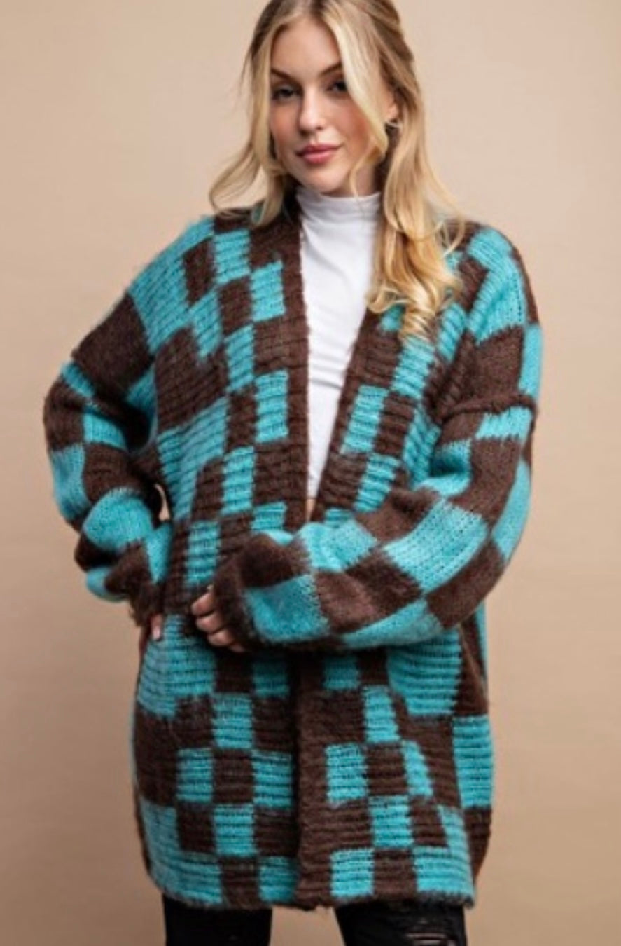 Woman wearing a checkered cardigan with brown and blue pattern